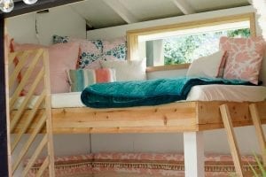 Shed detail: Lofted bed with throw pillows and blanket.